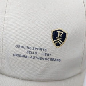 Detail of white baseball cap with premium embroidered shield logo and twill fabric texture