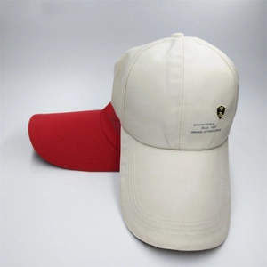 Detail of cotton baseball caps in beige and red with long brims and metal shields