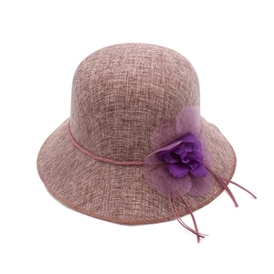 Détail d'un chapeau cloche brun rouge avec une grande fleur en organza violet et tissage