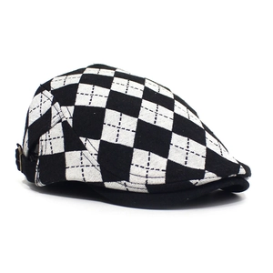 Detail view of black and white check pattern beret with bronze metal adjustment buckle