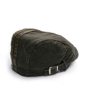 Détail du béret vintage vert foncé avec boucle métallique latérale et rayures sur le dessus