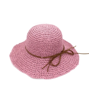 Detail of lavender woven raffia sun hat with delicate texture and brown bow ribbon