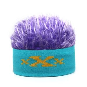 Detail of teal knit wig beanie featuring purple faux hair and yellow XXX embroidery