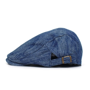 Detailed side view of blue denim beret featuring a vintage bronze adjustable metal buckle