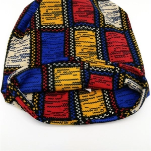 Kleurrijke geruite gebreide muts en nekwarmer met rood, blauw en geel ruitjespatroon