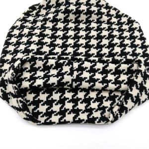 Gebreide muts met klassiek zwart-wit pied-de-poule patroon voor winterse warmte