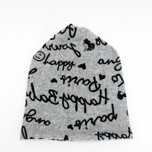 Hellgraue Strickmütze mit schwarzen Buchstaben-Prints und dekorativen Mustern