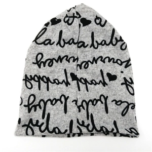 Detail der weichen hellgrauen Strickmütze für Babys mit schwarzem Buchstabendruck und Herzen