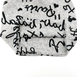Detailaufnahme von grauem Strickstoff mit schwarzem Paris-Schriftzug und Herz