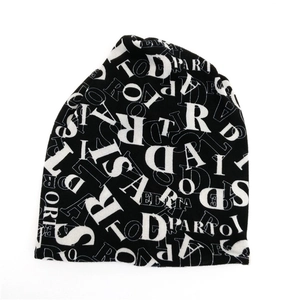 Dettaglio del berretto in maglia nera stile street con stampa di lettere bianche