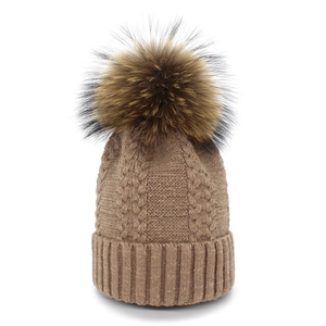 Women's winter cable knit beanie in brown with a fluffy 15cm raccoon fur pom pom