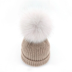 Minimalist light khaki knitted beanie with large fluffy faux fur pom-pom for winter warmth