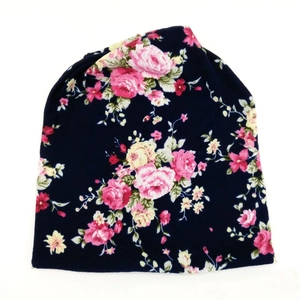 Slouchy beanie for women featuring pink floral rose print on a dark navy knit fabric