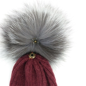 Burgunderfarbene Strickmütze mit grauem Pelzbommel und Druckknopf aus antiker Bronze