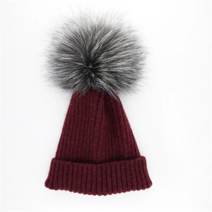 Dunkelrote Rippstrickmütze für Damen mit einem großen Silberfuchs-Pelzbommel-Detail