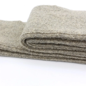 Winter wool scarf with fox fur balls shown in close-up of oatmeal knit texture