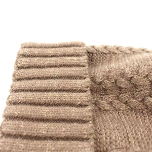 Brown knit winter hat with cable knit texture and ribbed cuff in close-up view