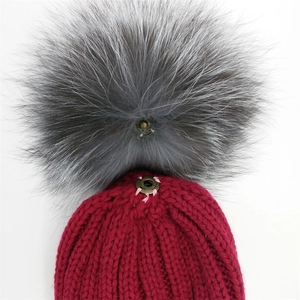 Winter knit beanie with detachable grey fox fur pom-pom showing metal snap fastener
