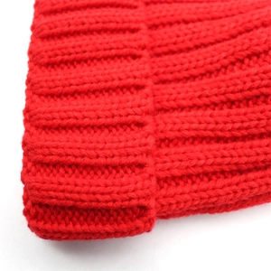 Close-up of the red ribbed knit beanie showing thick texture and warm folded cuff detail