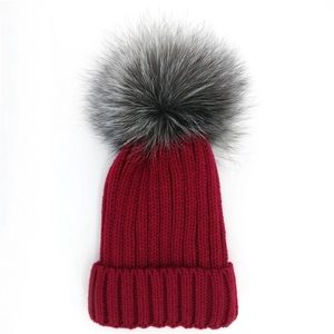 Classic burgundy ribbed knit beanie with a large fluffy fur pompom for winter warmth