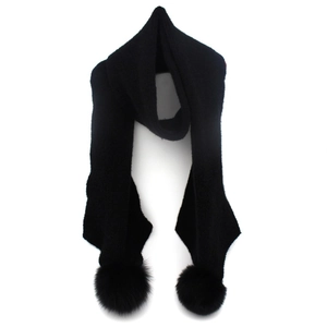 Detail of warm black knitted winter scarf featuring fluffy fox fur pom-pom accents