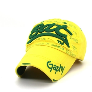 Detail of yellow baseball cap featuring green letter embroidery and street style distressing