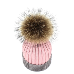Pink and grey cashmere knit beanie with a large fluffy faux fur pompom for winter warmth