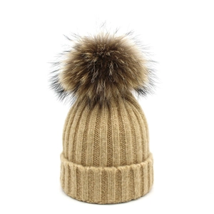 Beige wool knit beanie for women with large brown raccoon fur pompom and ribbed cuff