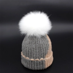 Women's autumn knit beanie featuring a white fur pompom and color-blocked ribbed design