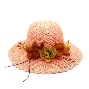 Women's straw sun hat with floral fabric accents and wavy brim for beach vacation