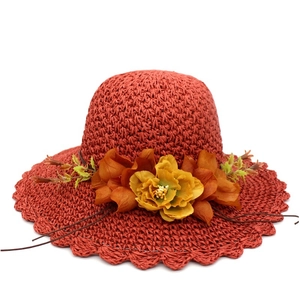 Rust red straw sun hat with large floral decoration and wavy scalloped brim for women