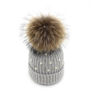 Gray knitted beanie with large faux fur pompom and elegant pearl embellishments