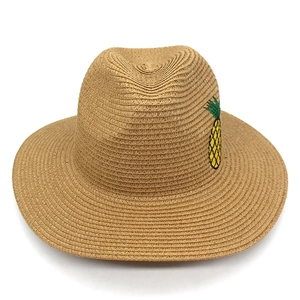 Détail de la broderie ananas jaune sur un chapeau de paille naturel pour l'été