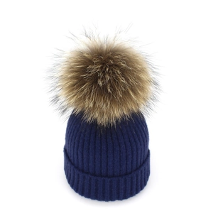 Navy blue ribbed knit beanie with a large fluffy brown faux fur pom pom on top