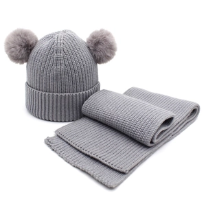 Dettaglio set cappello e sciarpa in maglia grigia con morbidi pompon in ecopelliccia