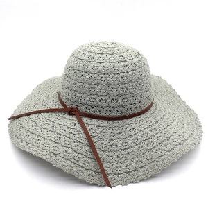 Light gray wide brim crochet sun hat with a brown leather decorative band and bow