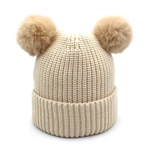 Cozy cream ribbed knit baby hat with two brown faux fur pom poms for winter warmth