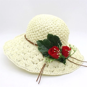 Close-up of woven raffia sun hat featuring red roses and brown leather cord detail