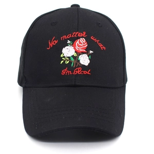 Detail of rose embroidery and text on black cotton baseball cap with curved brim