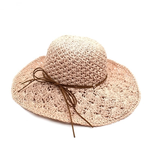 Women's raffia sun hat with wide wavy brim and delicate ribbon bow for beach travel
