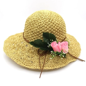 Detail of wide brim raffia sun hat with pink roses and woven texture for summer