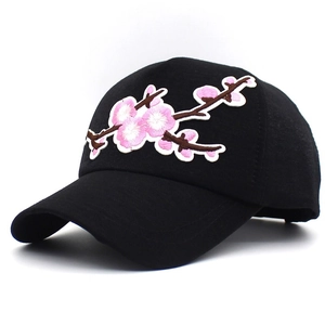 Close-up of detailed pink flower embroidery on a classic black cotton baseball cap