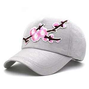 Detailed view of pink floral embroidery on a grey textile baseball cap with curved brim