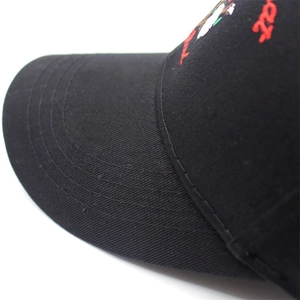 Detailed macro view of red cursive embroidery and stitching on black cotton baseball cap