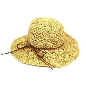 Women's raffia sun hat with wide wavy brim and brown ribbon bow for beach travel