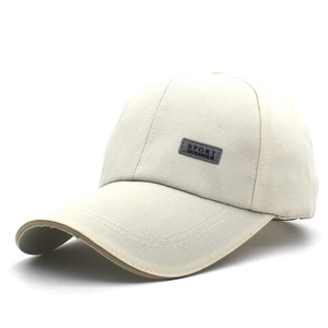 Détail d'une casquette beige avec badge SPORT et texture en toile de coton