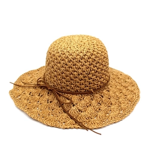 Detail of hand-woven raffia sun hat with scalloped brim and decorative leather bow strap