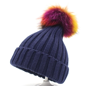 Winter dark blue ribbed knit hat featuring a colorful raccoon fur pom pom for warmth