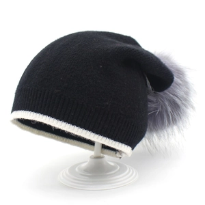 Bonnet en tricot d'hiver avec grand pompon en fausse fourrure grise et rayures contrastées