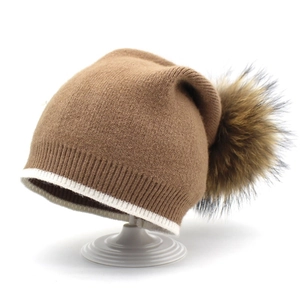 Bonnet en maille marron avec un grand pompon moelleux et revers à rayures blanches